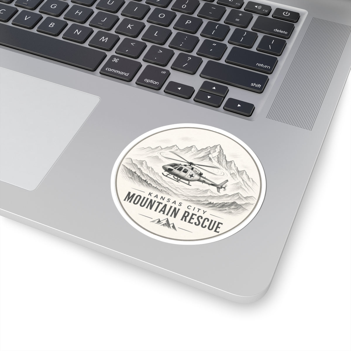 Round sticker: Kansas City Mountain Rescue, helicopter flying past sketched mountain range – view 3
