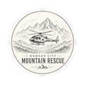 Round sticker: Kansas City Mountain Rescue, helicopter flying past sketched mountain range