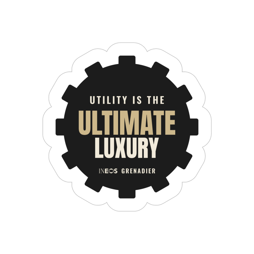 Utility Is the Ultimate Luxury die-cut sticker: UTILITY IS THE ULTIMATE LUXURY lettering in tan and white on a black gear-shaped badge